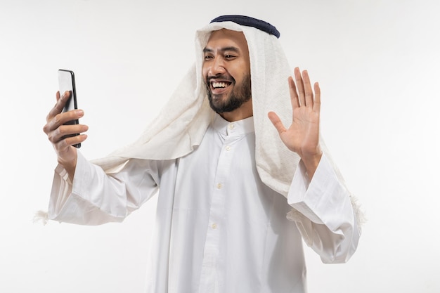 Man in een tulband met behulp van een mobiele telefoon videoconferentie en bellen