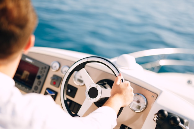 Man in een wit overhemd rijdt in een witte motorboot-closeup