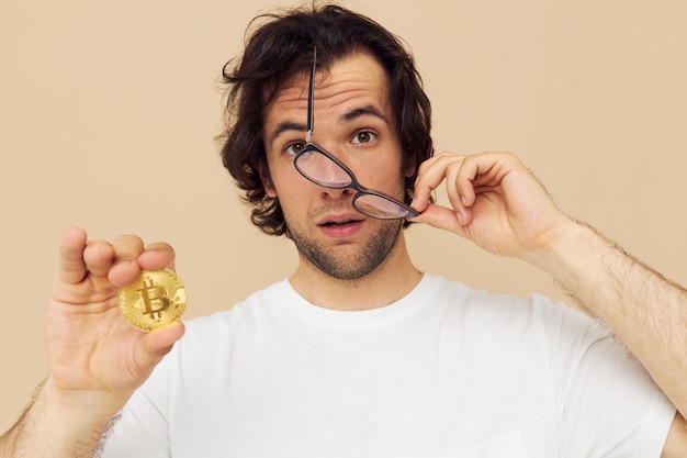 Man in een witte t-shirt met bitcoin cryptocurrency beige achtergrond