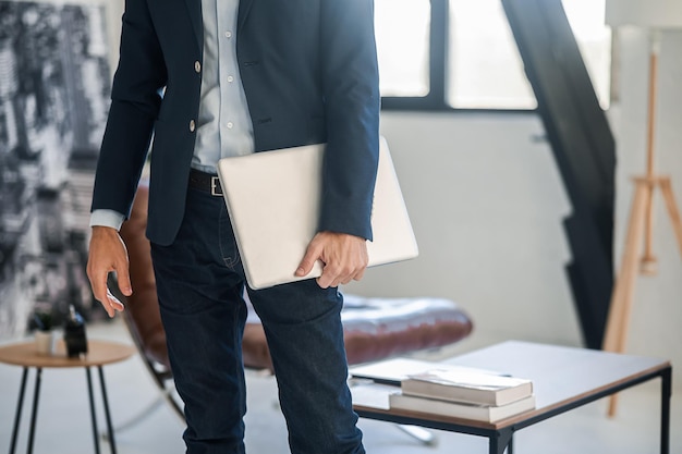 Man in een zwart elegant pak met een laptop