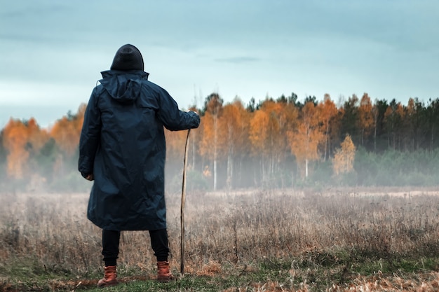 man in een zwarte jas bij mistig weer