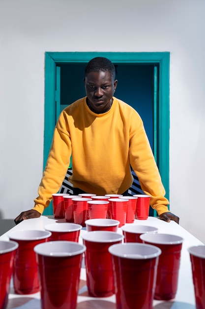 Man in gele sweater die bierpong speelt