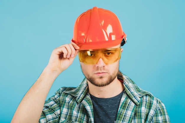 Foto man in groen shirt en beschermende oranje helm