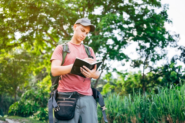 Man in het bos zijn dagboek schrijven