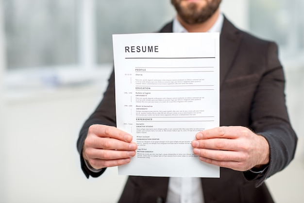 Man in het pak met cv voor het inhuren van een baan. Close-up gericht op het papier