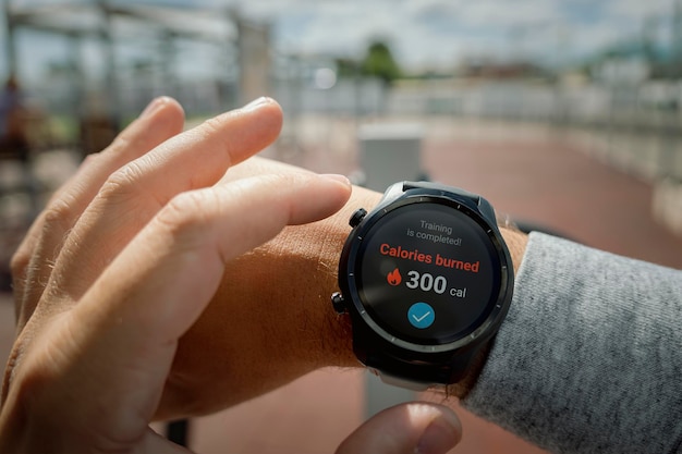 Man in het stadion controleert het aantal verbrande calorieën in zijn smartwatch Dagelijkse oefening in de frisse lucht voor gewichtsverlies Slimme gadgets voor sportpolshorlogeconcept