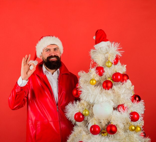 Man in kerstmuts met kerstboom nieuwjaarsconcept december bebaarde kerstman man in santa