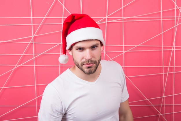 Man in kerstmuts wacht op kerstcadeau. online kerstinkopen. gelukkig nieuwjaar. De ochtend voor Kerstmis. gelukkige kerstman. levering kerstcadeaus. Kerst compositie. Kerstfeest op kantoor.