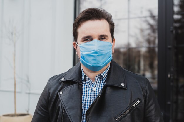 Man in masker op een achtergrond van gesloten café, coronavirus, ziekte, infectie, quarantaine, medisch masker