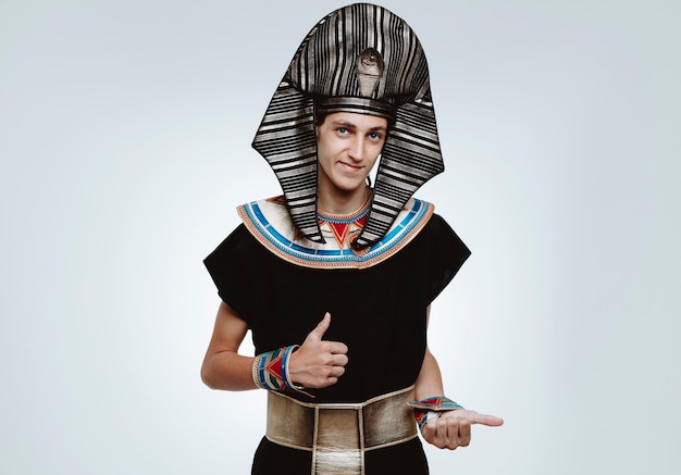 Man in oud egyptisch kostuum blij en positief glimlachend vrolijk duimen omhoog op wit