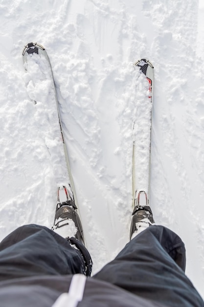 Man in outfit monteert ski-standpunt van boven naar beneden