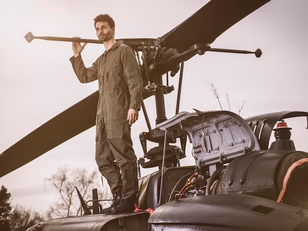 写真 ヘリコプターの上に立つオーバーオールを着た男性