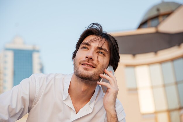 Man in overhemd met telefoon. opzoeken