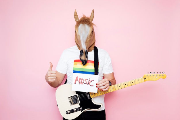 man in paardenmasker met duim omhoog met een bordje met de tekst "muziek"