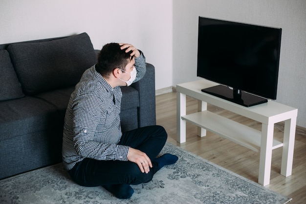 写真 テレビのニュースを見ているパニックの男