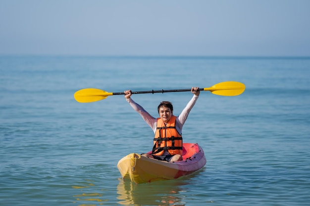 Man in reddingsvest die een kajakboot in de zee peddelt