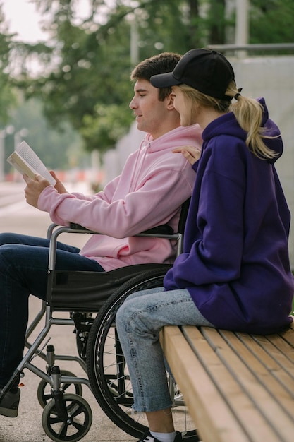 Foto man in rolstoel en vrouw die samen een boek lezen foto