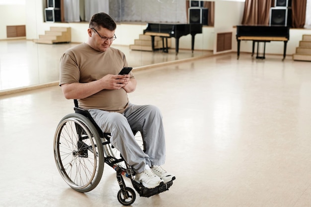 Man in rolstoel met een smartphone