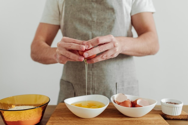 Man in schort koken aan de gang Eieren meel zout op de tafel snijplank en mes