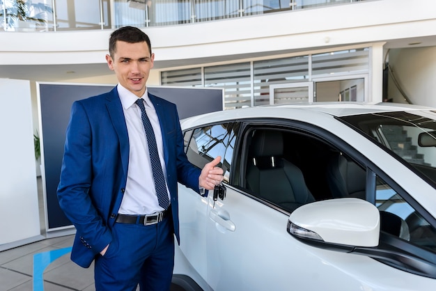 Man in showroom met sleutels van nieuwe auto