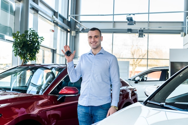 Man in showroom met sleutels van nieuwe auto