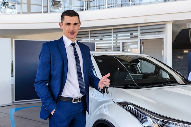 Man in showroom met sleutels van nieuwe auto