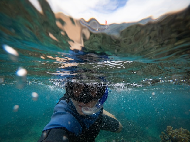 Man in snorkelmasker doet selfie onderwateravontuur en reisconcept