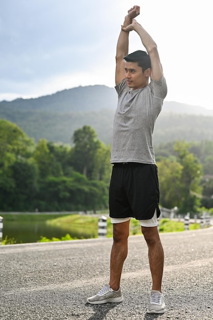 Man in sportkleding die zijn armen strekt om op te warmen, maak je klaar om te gaan joggen