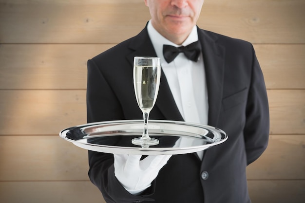 写真 漂白された木製の板の背景にシャンパンとグラスを提供するスーツを着た男