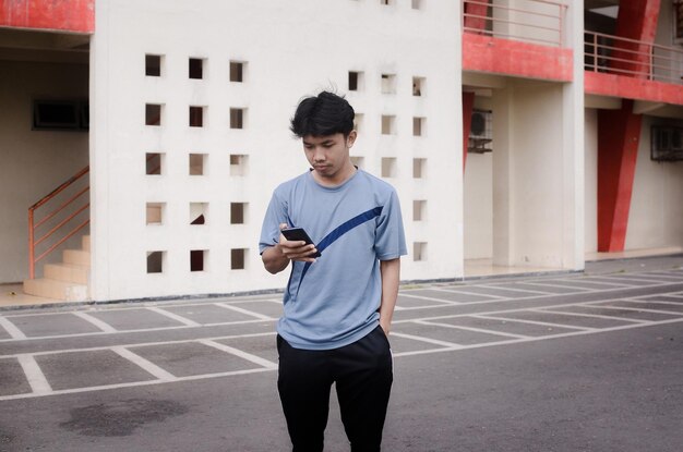 사진 화창한 날에 휴대폰으로 소셜 네트워크에 글을 쓰는 운동복을 입은 남자