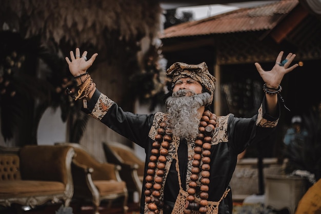 Foto man in traditionele kleding die buiten staat en gebaren maakt