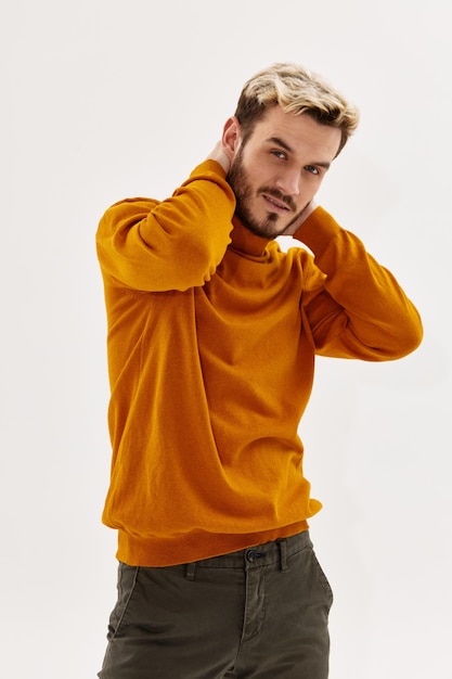 Man in trui houdt zijn hand achter zijn hoofd mode herfststijl poseren levensstijl