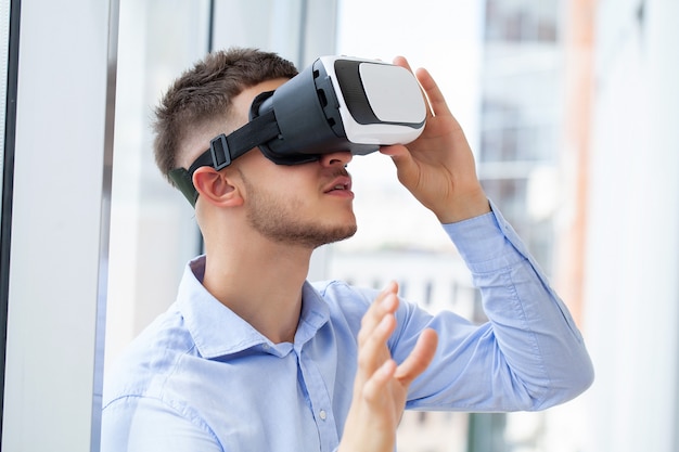 Man in VR-headset die objecten in virtual reality probeert aan te raken