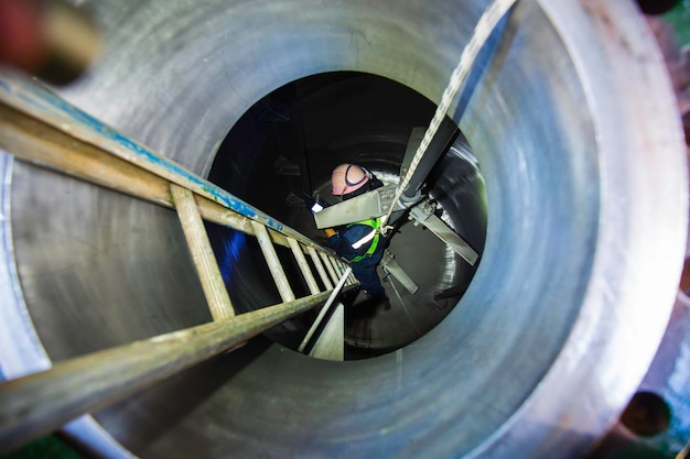 Man in werkinspectie proces chemische stof in chemische roestvrijstalen tank