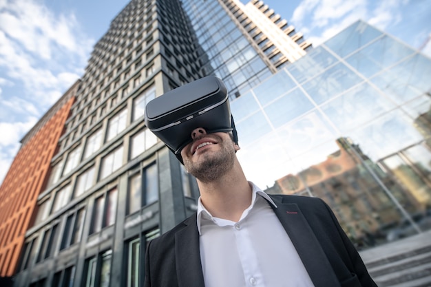 Foto man in zwart pak met vr-bril en op zoek genoten