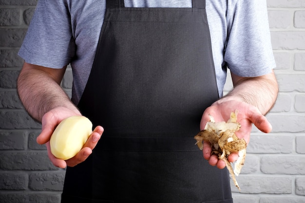 Man in zwarte schort met aardappelen