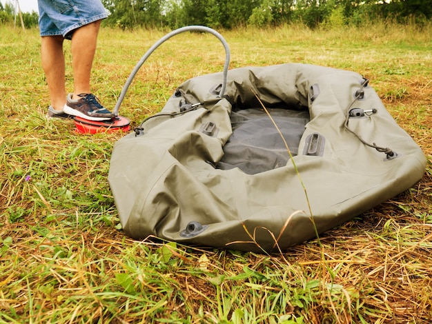 A man inflates a rubber boat with a pump