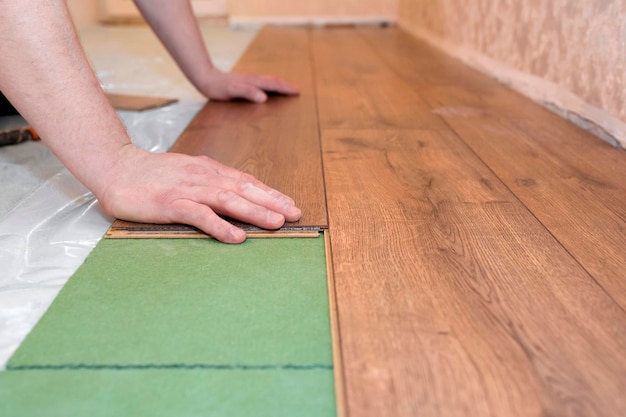 Man installeert een gelamineerde houten vloer Reparatieconcept