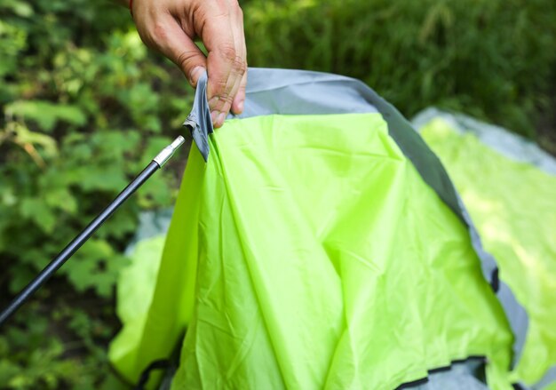 Man installeren tent. Toeristische buitenshuis. Kamperen in het bos.