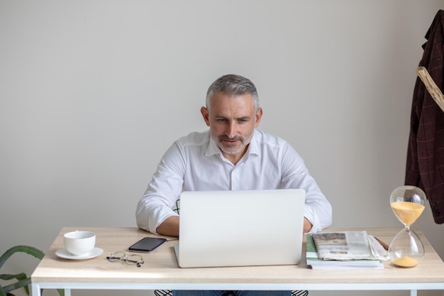 Man intently looking at laptop screen sitting at table