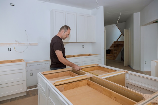 Man interior designer using tape measure on on domestic kitchen counter