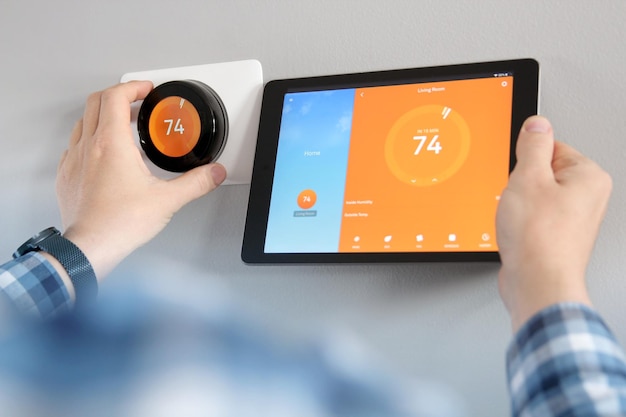 Foto l'uomo sta regolando una temperatura utilizzando un tablet con l'app per la casa intelligente nel soggiorno moderno