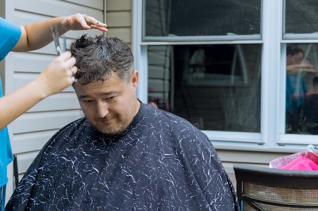 男性は男性の家のヘアカットスタイリングで周りにいます