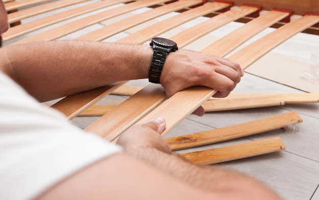 The man is assembling wooden furniture in home