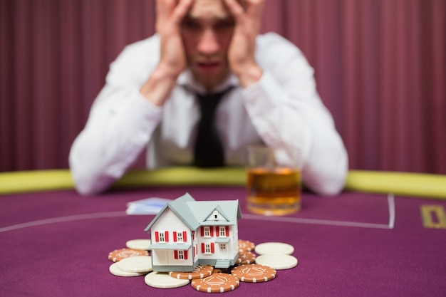 Foto l'uomo sta scommettendo la sua casa al gioco del poker