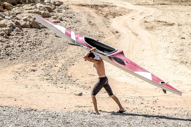 A man is carrying a sports boat