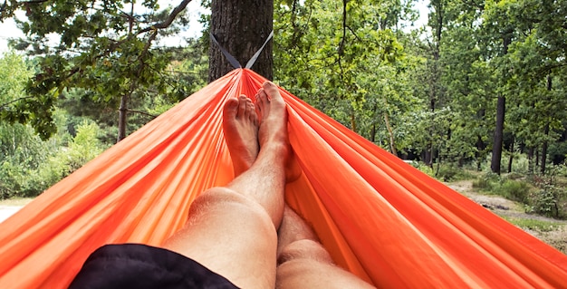 Man is chilling and relaxing in the hammock in the camp