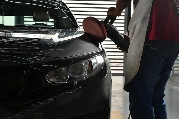 A man is cleaning a car with a red light.