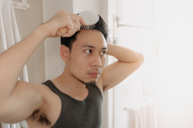 写真 男はバスルームで髪をとかしている