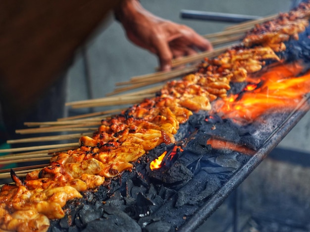 A man is cooking food on a grill with the words